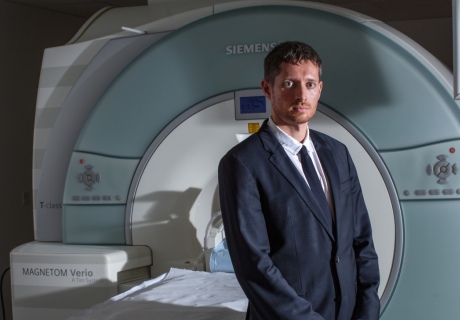 Dr Carhart-Harris stands by an MRI scanner