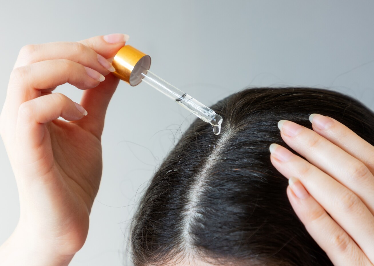 Hair growth oil being put onto a scalp